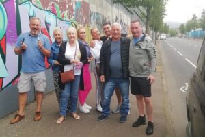 Belfast's Political Mural Taxi Tour - International Mural Wall on Divis Street: photos, questions, and stories tied to place
